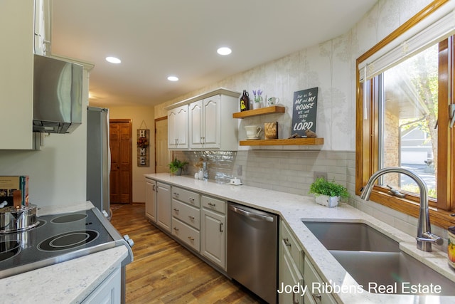 226 Sunset Ave NW, Grand Rapids, MI 49504 - kitchen featuring dishwasher, a sink, light wood-type flooring, decorative backsplash, and range