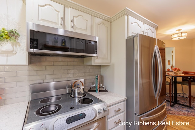 226 Sunset Ave NW, Grand Rapids, MI 49504 - kitchen with stainless steel appliances, light stone countertops, backsplash, and wood finished floors