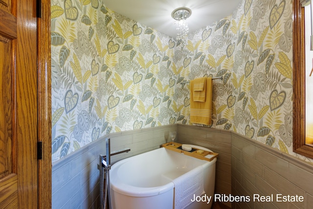 226 Sunset Ave NW, Grand Rapids, MI 49504 - bathroom with wallpapered walls, wainscoting, tile walls, and a garden tub