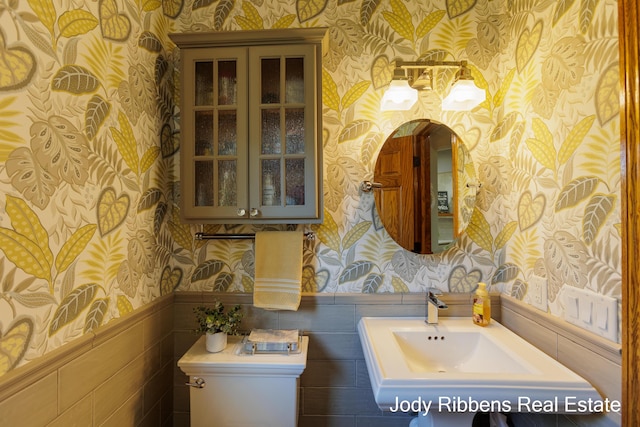 226 Sunset Ave NW, Grand Rapids, MI 49504 - half bathroom with wallpapered walls, wainscoting, toilet, and a sink