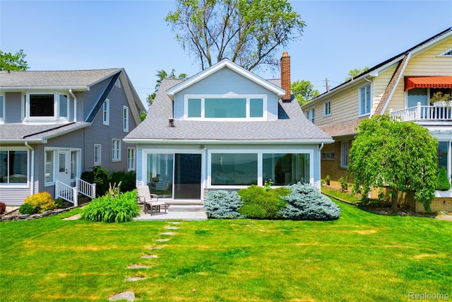 29899 E River Rd, Grosse Ile, MI 48138 - back of house with entry steps, a lawn, a chimney, a patio, and roof with shingles