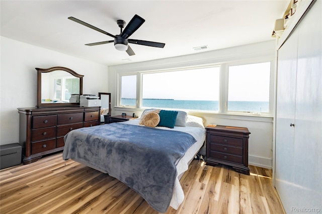 29899 E River Rd, Grosse Ile, MI 48138 - bedroom featuring wood finished floors, ceiling fan, baseboards, and a water view