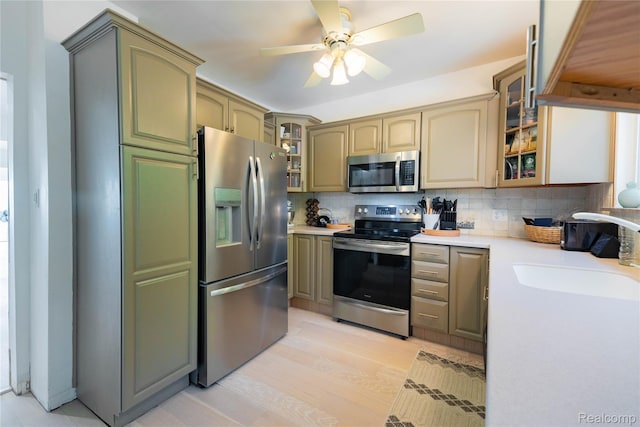 29899 E River Rd, Grosse Ile, MI 48138 - kitchen featuring stainless steel appliances, light countertops, backsplash, a sink, and a ceiling fan