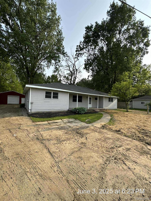 7025 Coldwater Rd, Flushing, MI 48433 - ranch-style home with dirt driveway, a detached garage, and an outdoor structure