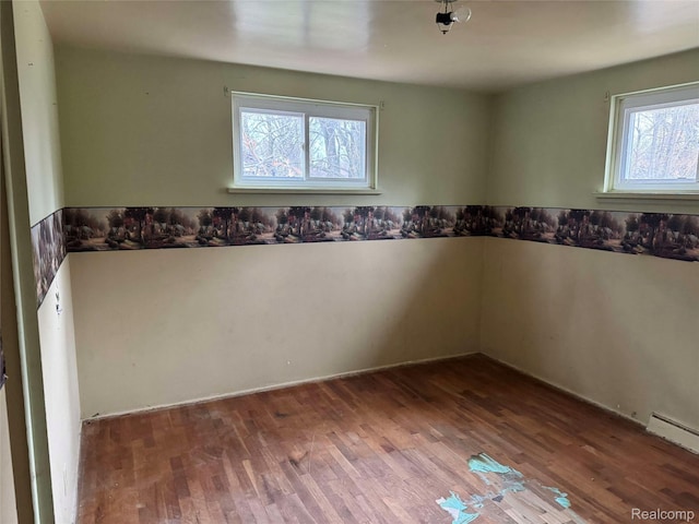 7025 Coldwater Rd, Flushing, MI 48433 - unfurnished room with wood finished floors and a baseboard heating unit