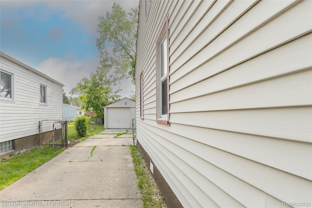 23123 Lambrecht Ave, Eastpointe, MI 48021 - view of home's exterior with concrete driveway, an outbuilding, a garage, and a gate