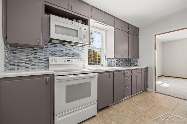 5200 Swede Ave, Midland, MI 48640 - kitchen featuring white appliances, a sink, gray cabinets, tasteful backsplash, and light countertops