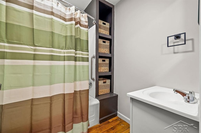 5200 Swede Ave, Midland, MI 48640 - bathroom with wood finished floors, vanity, a shower with curtain, and baseboards