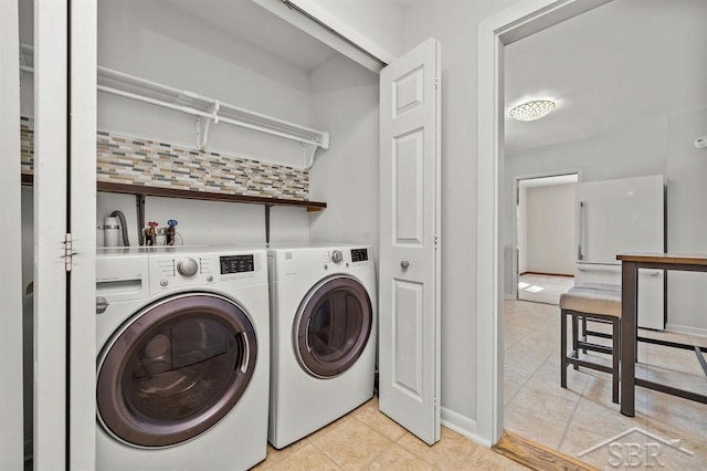 5200 Swede Ave, Midland, MI 48640 - laundry area featuring washing machine and dryer, light tile patterned floors, and baseboards