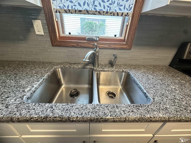3117 Morin Point St, Erie, MI 48133 - kitchen view of a sink, tasteful backsplash, stone countertops, and white cabinets