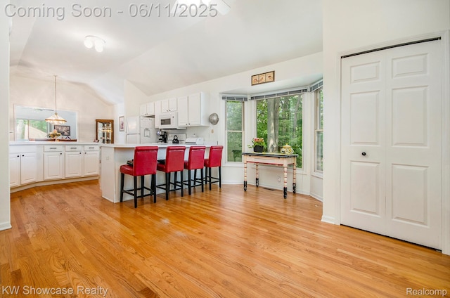 3675 S Commerce Rd, Commerce Twp, MI 48390 - kitchen with white appliances, a kitchen breakfast bar, white cabinetry, light countertops, and light wood-type flooring