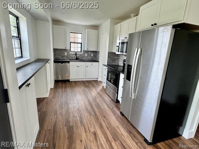 17772 Clark St, Riverview, MI 48193 - kitchen featuring stainless steel appliances, a sink, dark countertops, backsplash, and white cabinetry