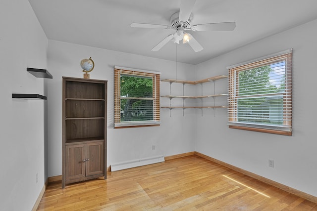 817 Cherry Ave, Big Rapids, MI 49307 - spare room featuring a baseboard heating unit, light wood finished floors, baseboards, and a ceiling fan