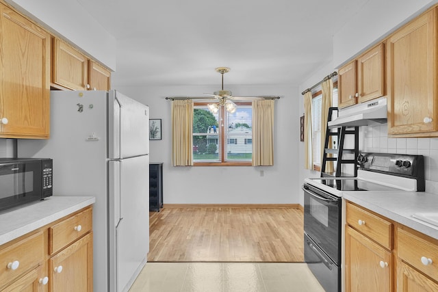 817 Cherry Ave, Big Rapids, MI 49307 - kitchen featuring electric stove, under cabinet range hood, black microwave, a ceiling fan, and backsplash