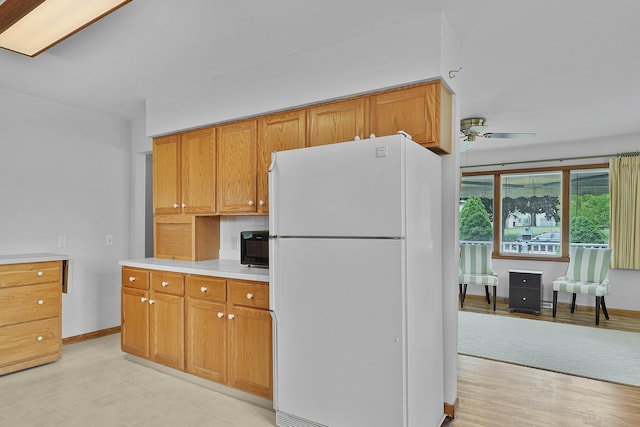 817 Cherry Ave, Big Rapids, MI 49307 - kitchen featuring freestanding refrigerator, light countertops, a ceiling fan, baseboards, and brown cabinets