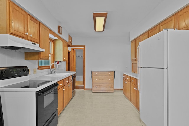 817 Cherry Ave, Big Rapids, MI 49307 - kitchen with freestanding refrigerator, under cabinet range hood, range with electric stovetop, a sink, and light countertops