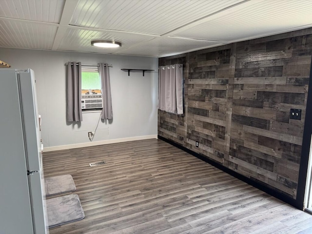 728 Crystal Ln, Mears, MI 49436 - spare room featuring baseboards, wood finished floors, and wood walls