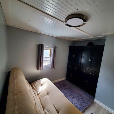 728 Crystal Ln, Mears, MI 49436 - living area featuring wood ceiling and baseboards
