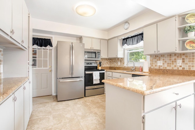 802 Kay St, Otsego, MI 49078 - kitchen featuring stainless steel appliances, open shelves, a sink, tasteful backsplash, and a peninsula