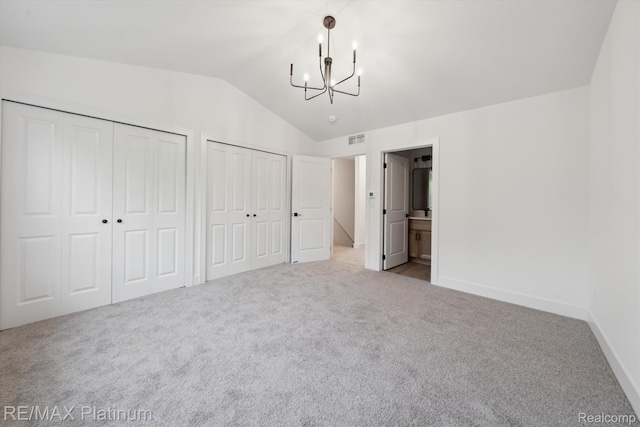 1689 Pinecroft Ln, Howell, MI 48855 - unfurnished bedroom featuring multiple closets, a chandelier, carpet floors, vaulted ceiling, and ensuite bath