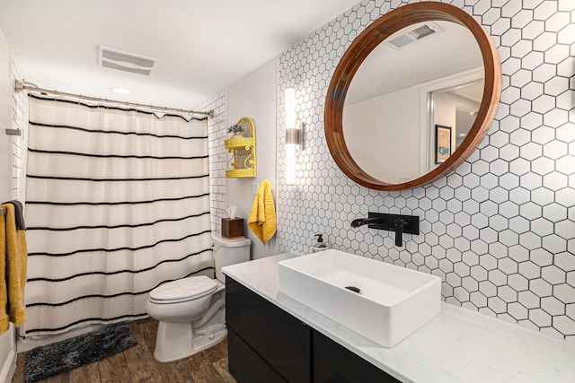 2140 Pauline Blvd Unit 108, Ann Arbor, MI 48103 - bathroom featuring toilet, wood finished floors, tile walls, vanity, and a shower with shower curtain