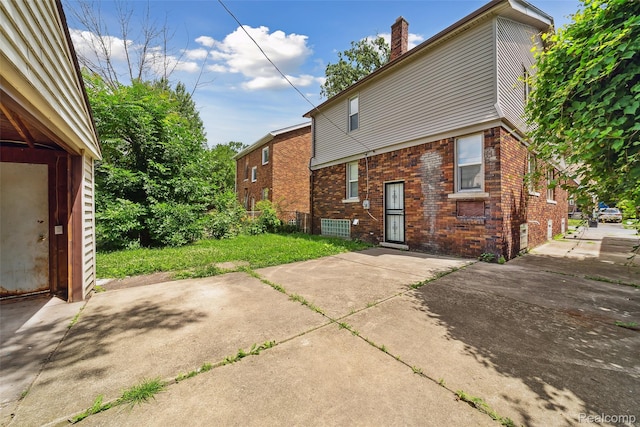 4835 Bedford St, Detroit, MI 48224 - view of property exterior with brick siding, a patio, and a chimney