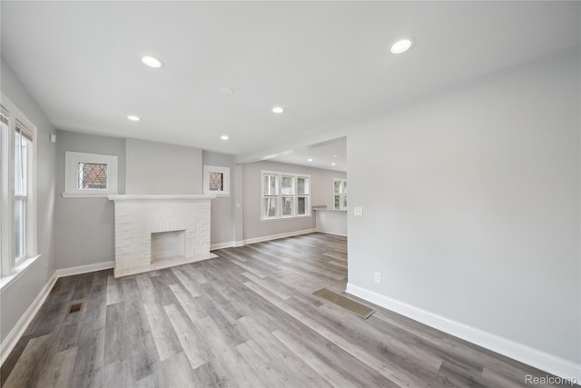 4835 Bedford St, Detroit, MI 48224 - unfurnished living room featuring recessed lighting, wood finished floors, baseboards, and a brick fireplace