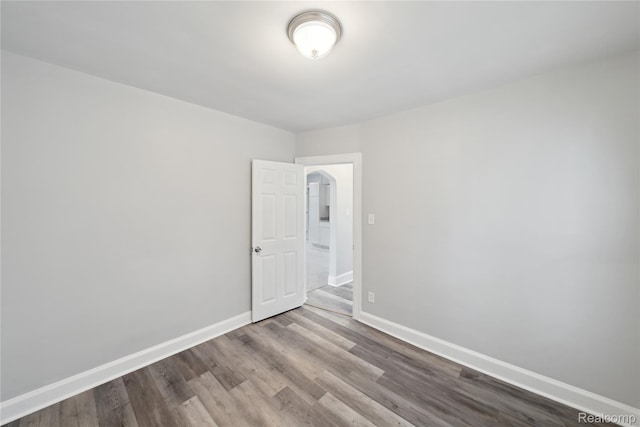 4835 Bedford St, Detroit, MI 48224 - empty room featuring wood finished floors, arched walkways, and baseboards