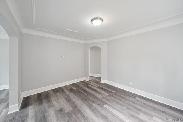 4835 Bedford St, Detroit, MI 48224 - empty room featuring arched walkways, wood finished floors, and baseboards
