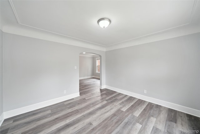 4835 Bedford St, Detroit, MI 48224 - empty room with arched walkways, wood finished floors, and baseboards