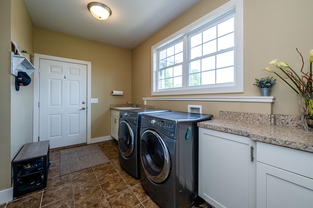 1640 Prairie Dr, Saint Joseph, MI 49085 - laundry area featuring washer and clothes dryer, cabinet space, stone finish floors, and baseboards