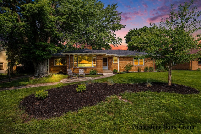 2308 Godwin Ave SE, Grand Rapids, MI 49507 - view of front of home featuring a lawn, a chimney, and brick siding