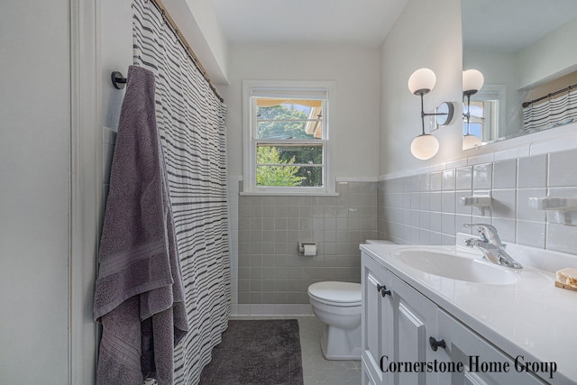 2308 Godwin Ave SE, Grand Rapids, MI 49507 - full bath with toilet, tile patterned flooring, vanity, tile walls, and a wainscoted wall