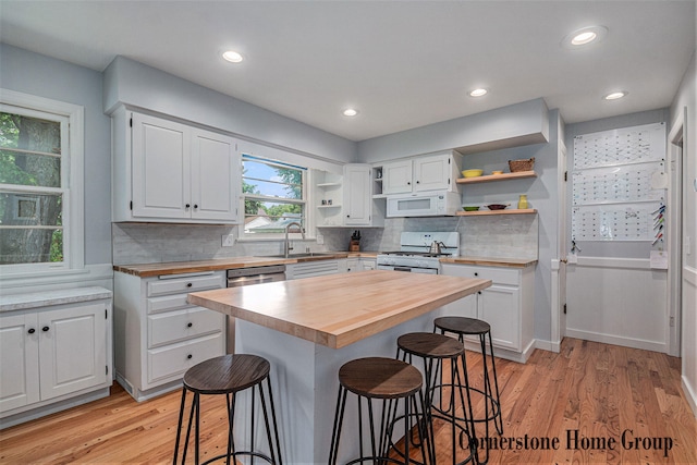 2308 Godwin Ave SE, Grand Rapids, MI 49507 - kitchen featuring white appliances, wooden counters, open shelves, a sink, and a kitchen breakfast bar