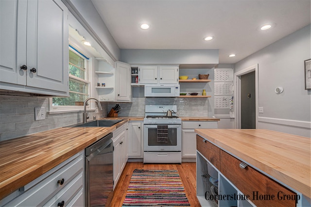 2308 Godwin Ave SE, Grand Rapids, MI 49507 - kitchen with butcher block counters, white appliances, open shelves, a sink, and light wood-style floors