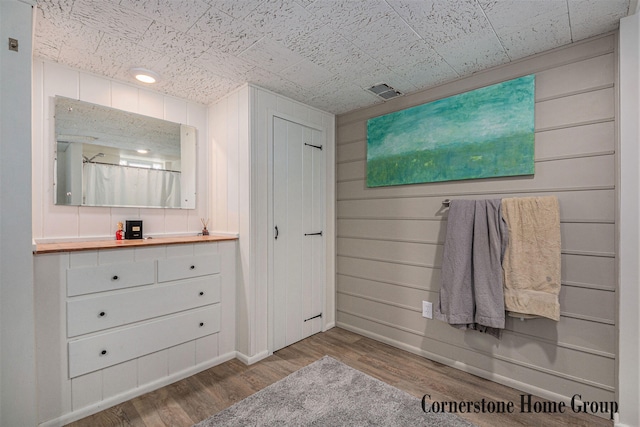 2308 Godwin Ave SE, Grand Rapids, MI 49507 - bathroom featuring wood finished floors, vanity, baseboards, and wood walls