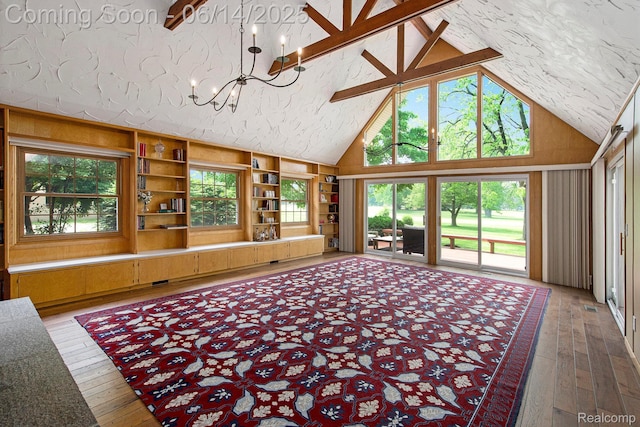 9818 Burning Tree Dr, Grand Blanc, MI 48439 - living area featuring a chandelier, hardwood / wood-style flooring, high vaulted ceiling, plenty of natural light, and built in shelves