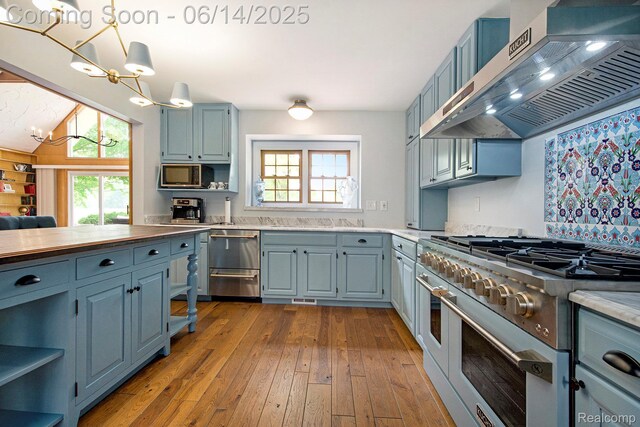 9818 Burning Tree Dr, Grand Blanc, MI 48439 - kitchen featuring appliances with stainless steel finishes, ventilation hood, open shelves, blue cabinetry, and hardwood / wood-style flooring