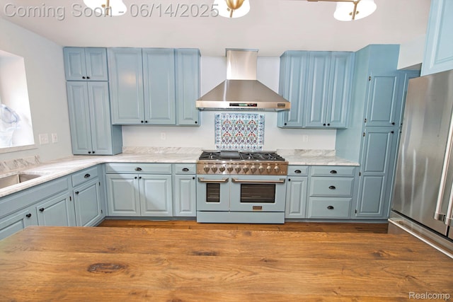 9818 Burning Tree Dr, Grand Blanc, MI 48439 - kitchen featuring stainless steel appliances, wall chimney exhaust hood, and blue cabinets