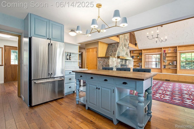9818 Burning Tree Dr, Grand Blanc, MI 48439 - kitchen featuring high quality fridge, a chandelier, open shelves, butcher block countertops, and blue cabinets