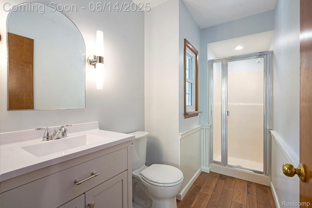9818 Burning Tree Dr, Grand Blanc, MI 48439 - full bathroom with wood finished floors, a shower stall, toilet, vanity, and wainscoting