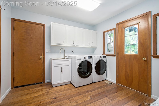 9818 Burning Tree Dr, Grand Blanc, MI 48439 - laundry room with cabinet space, light wood-style flooring, washer and clothes dryer, and baseboards