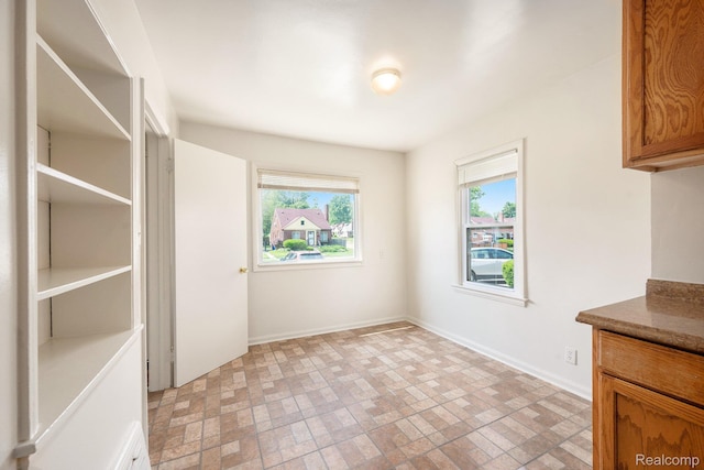 18930 Curtis St, Highland Park, MI 48219 - unfurnished dining area with healthy amount of natural light, brick patterned flooring, and baseboards