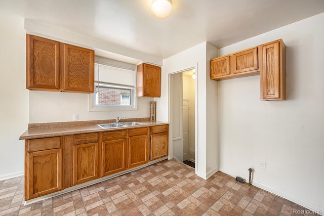 18930 Curtis St, Highland Park, MI 48219 - kitchen with a sink, baseboards, brown cabinetry, and brick patterned floors