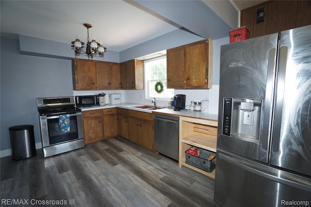 20375 Sumpter Rd, Belleville, MI 48111 - kitchen featuring stainless steel appliances, light countertops, a chandelier, dark wood-type flooring, and brown cabinets
