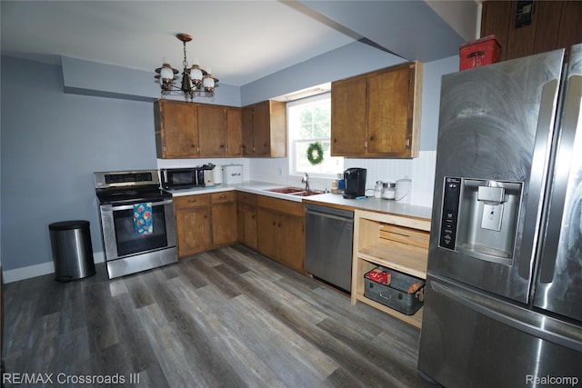 20375 Sumpter Rd, Belleville, MI 48111 - kitchen featuring appliances with stainless steel finishes, a chandelier, light countertops, brown cabinetry, and dark wood-style flooring