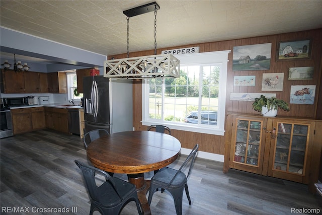 20375 Sumpter Rd, Belleville, MI 48111 - dining space with a chandelier, dark wood-style flooring, and wooden walls