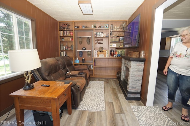 20375 Sumpter Rd, Belleville, MI 48111 - living area featuring light wood-style flooring, a fireplace, and wood walls