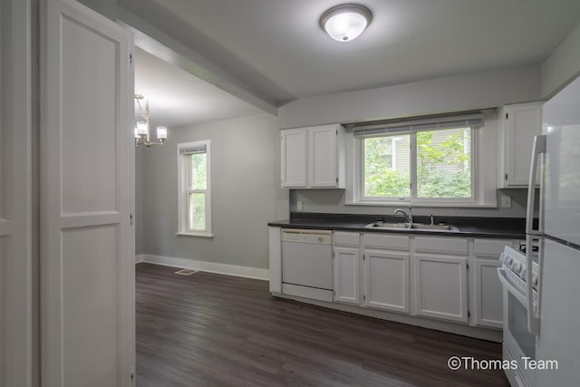 41 Grove St NE, Grand Rapids, MI 49505 - kitchen with a sink, white appliances, dark countertops, baseboards, and white cabinets