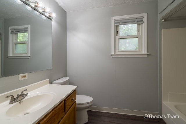 41 Grove St NE, Grand Rapids, MI 49505 - bathroom featuring toilet, plenty of natural light, baseboards, vanity, and a textured ceiling